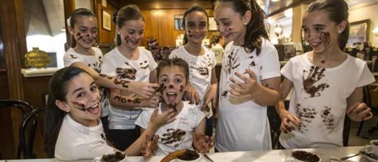 Las niñas merendaron chocolate con churros, después se pintaron caras, brazos y camisetas, y más tarde escribieron sobre Hogueras en unas cartulinas.