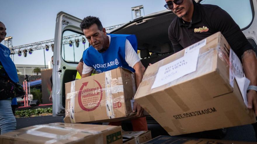 Voluntarios de entidades solidarias recogen en Mercatenerife productos donados durante un telemaratón.