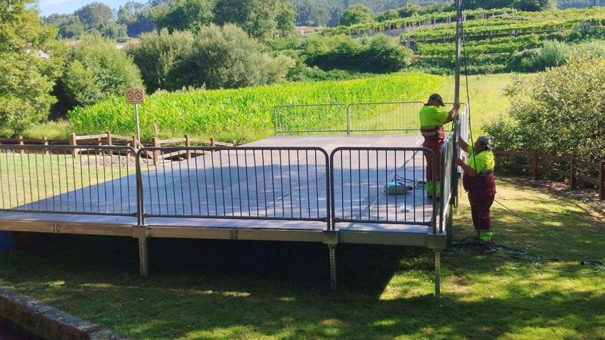 Los operarios municipales acondicionando la zona e instalando el palco. | T. Hermida