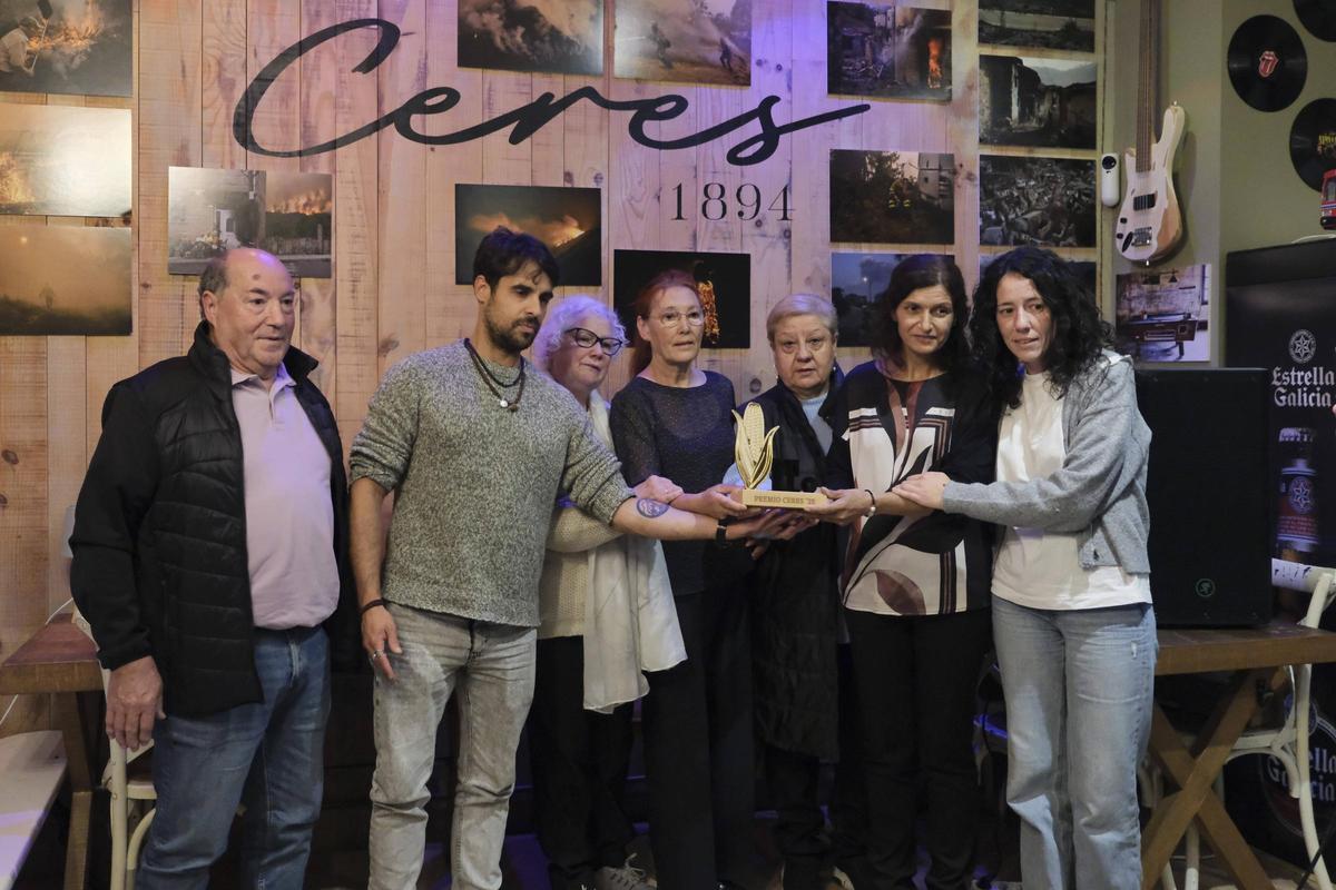 El fotoperiodista Brais Lorenzo, uno de los integrantes del jurado, entrega el premio 'Millo' a los vecinos de San Vicente.