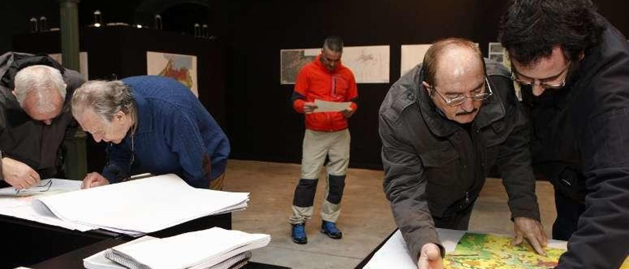 Varios ciudadanos, consultando ayer los documentos.