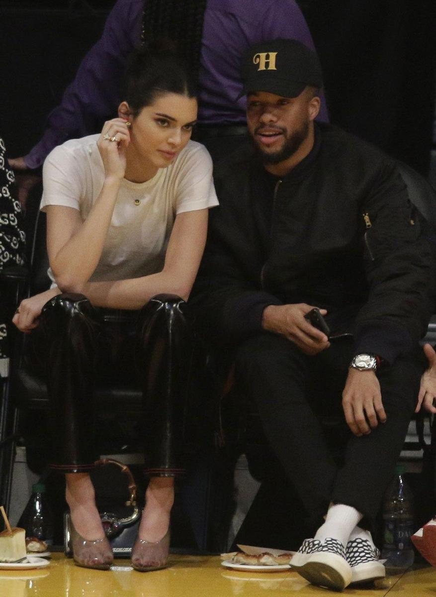 Kendall Jenner habla con un amigo durante un partido de la NBA
