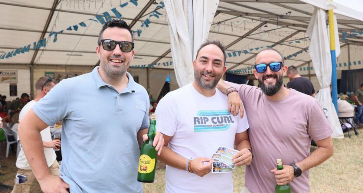 Por la izquierda, Nacho Arias, David González y Adrián González, ayer, con sidra y los vales de la comida popular. | MARIO CANTELI