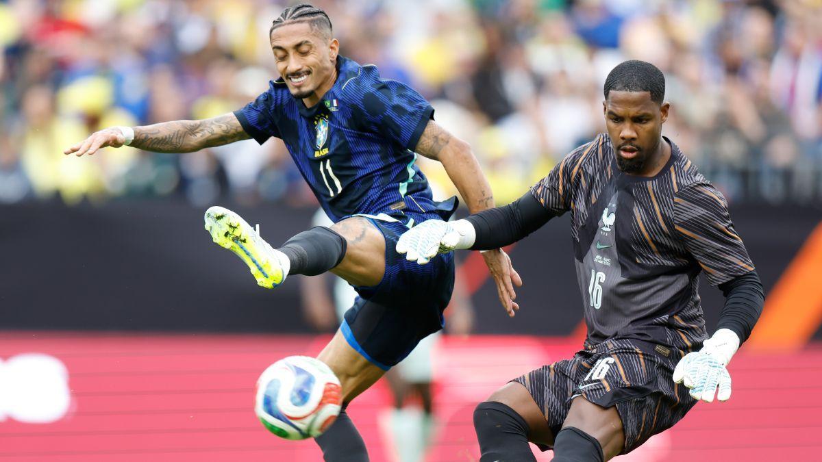 Raphinha en una acción con el portero francés Maignan