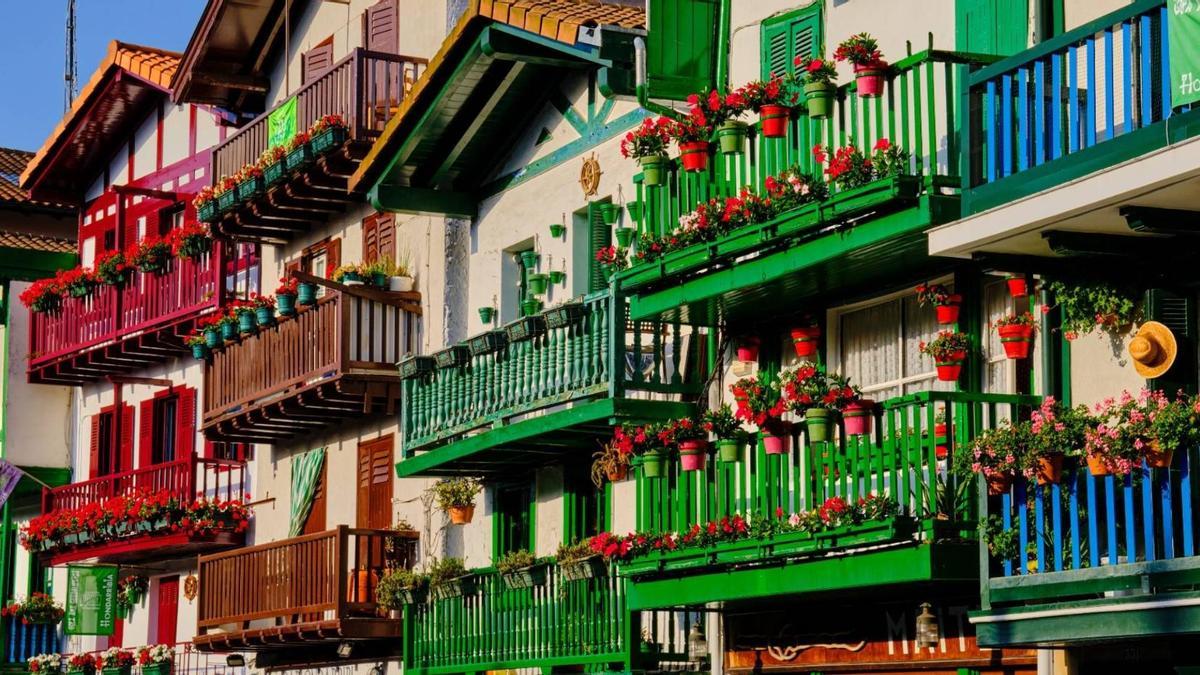 Las tradicionales fachadas blancas del barrio de La Marina decoradas con balcones de colores verdes, rojos y azules, adornados con flores y ropa tendida