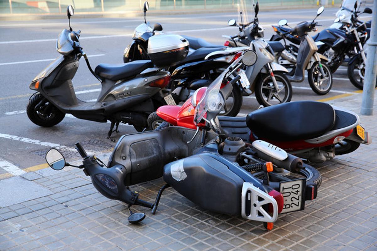 El fort vent tira a terra diverses motos al passeig de Taulat de Barcelona, aquest dimarts.
