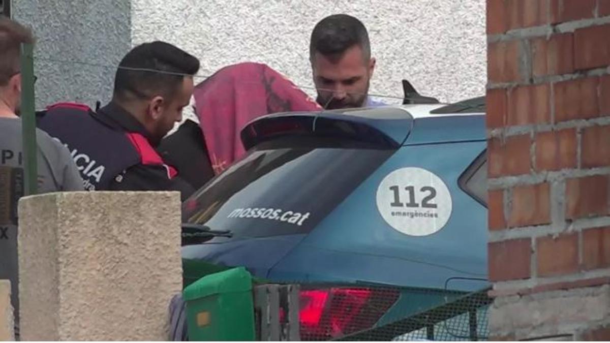 Los Mossos se llevan al detenido tras la reconstrucción del crimen de Bellcaire d'Empordà