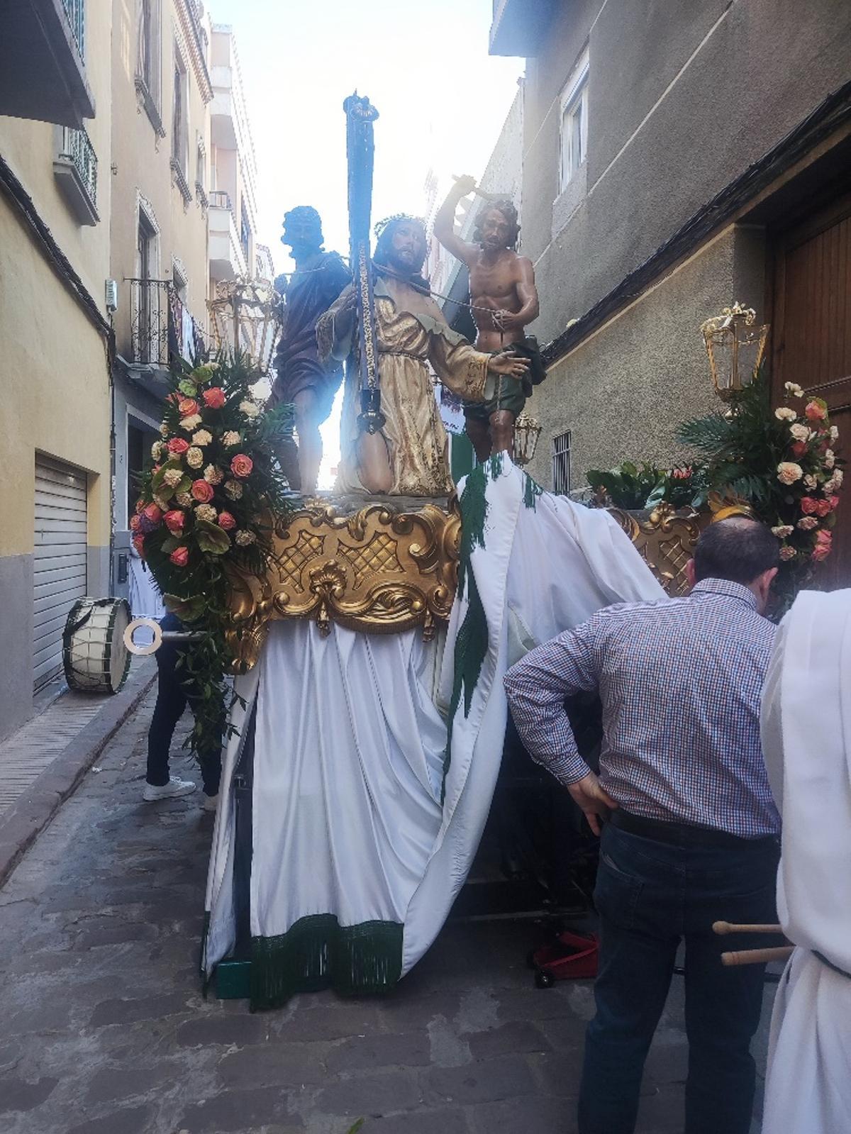 Cofrades de la Santa Faz intentan arreglar el carro del Cristo el Viernes Santo.
