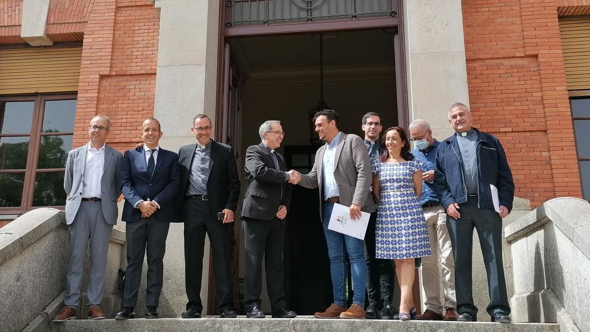 El Obispo y el alcalde, en el centro de la imagen, sellan el acuerdo con un apretón de manos