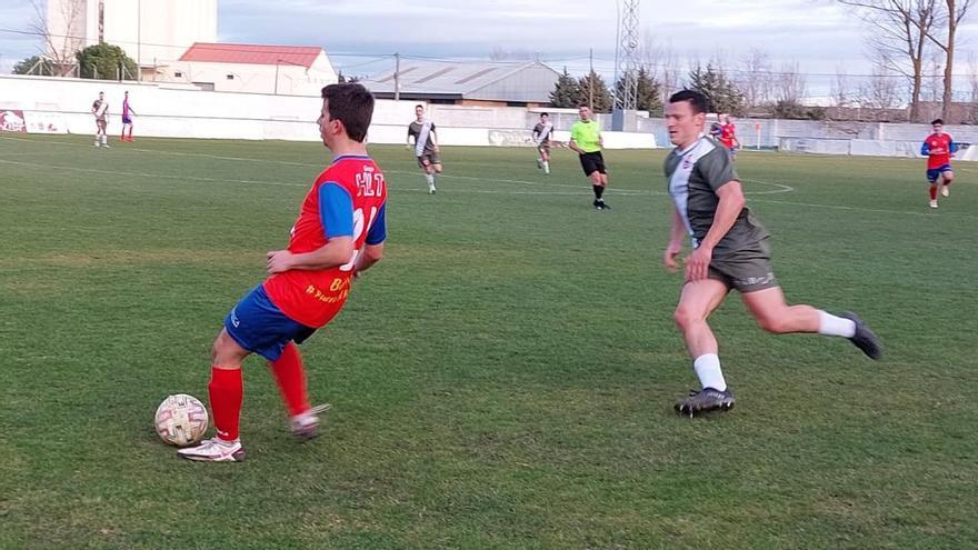 Un jugador del Benavente pasa el balón ante la presión de un rival.