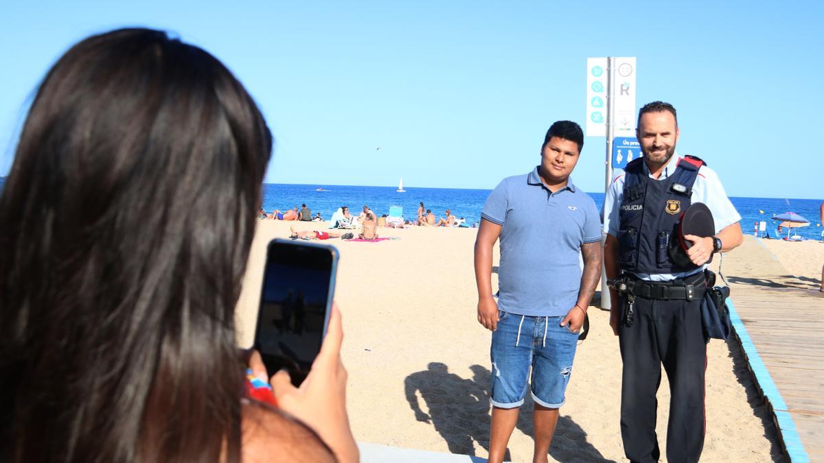 La parella de Bryan Gabino fent-li una foto amb l&#039;agent dels Mossos que li va salvar la vida a Platja d&#039;Aro. Imatge publicada el xx d&#039;agost del 2021. (Horitzontal)