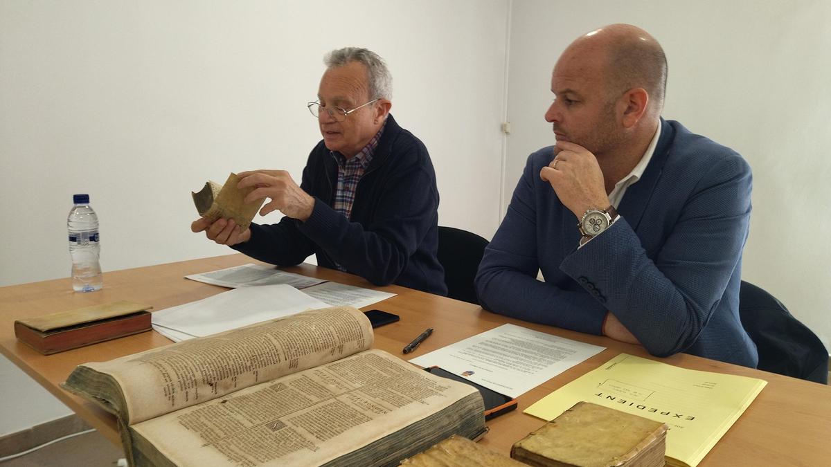 Tomás Merlos hojea uno de los libros ante el alcalde