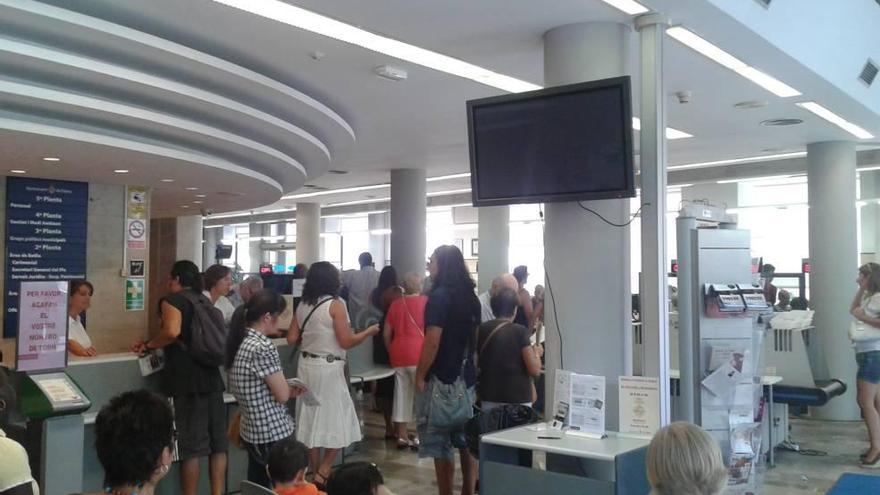 Ciudadanos esperando a ser atendidos en la oficina municipal de Santa Eulàlia.