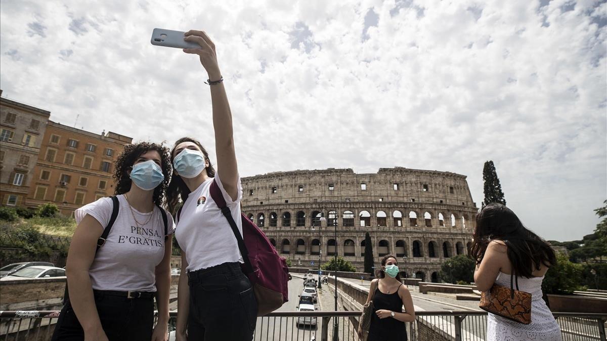 Dos jóvenes se hacen un ’selfie’ frente al Coliseum, hoy lunes en Roma.