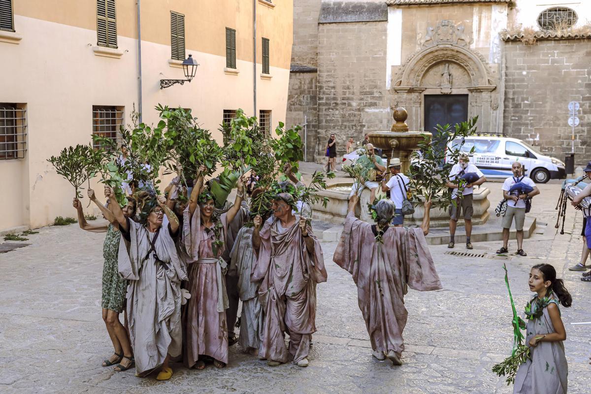Vecinos de la Calatrava y Canamunt, muchos vestidos de verde y con ramas de árboles, se unen durante sus cercavilas para homenajear a los bellasombras talados en la plaza Llorenç Villalonga.