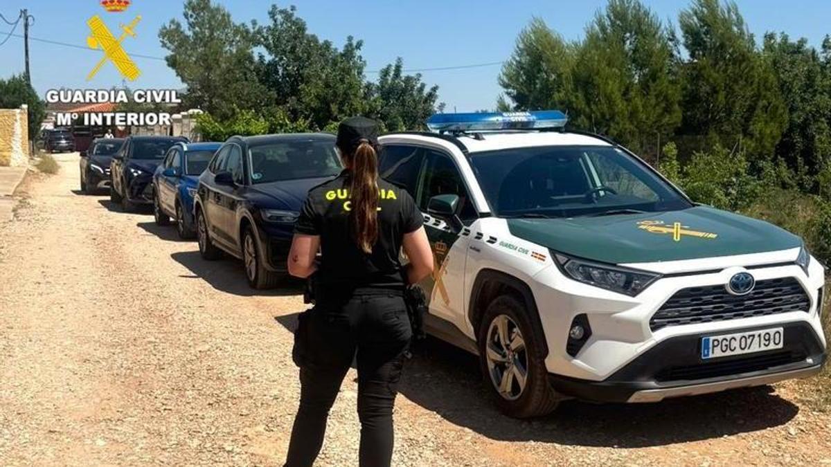 Una agente de la Guardia Civil con los vehículos recuperados en Montroi.