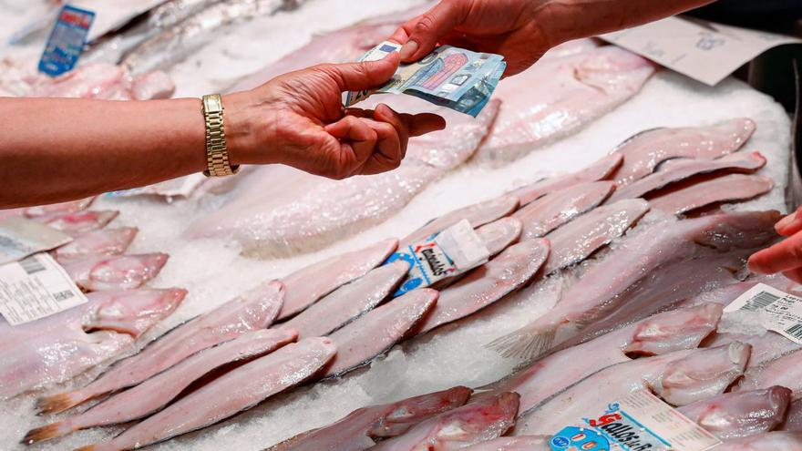 Clientes compran pescado en una pescadería. | Emilio Fraile