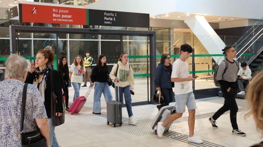 Pasajeros a la salida de un tren del Eje Atlántico el viernes en la estación de Urzáiz. |   // PEDRO FERNÁNDEZ