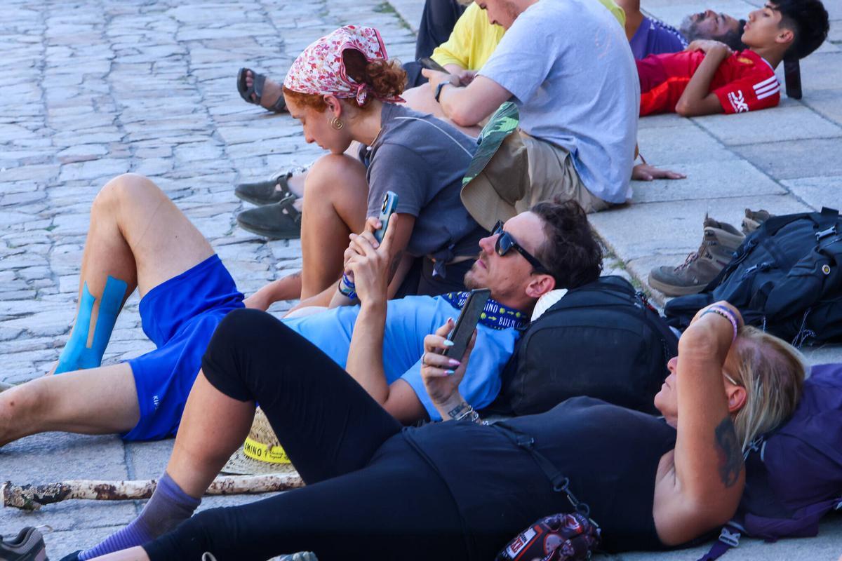 Peregrinos descansan en O Obradoiro esta semana tras el Camino de Santiago.