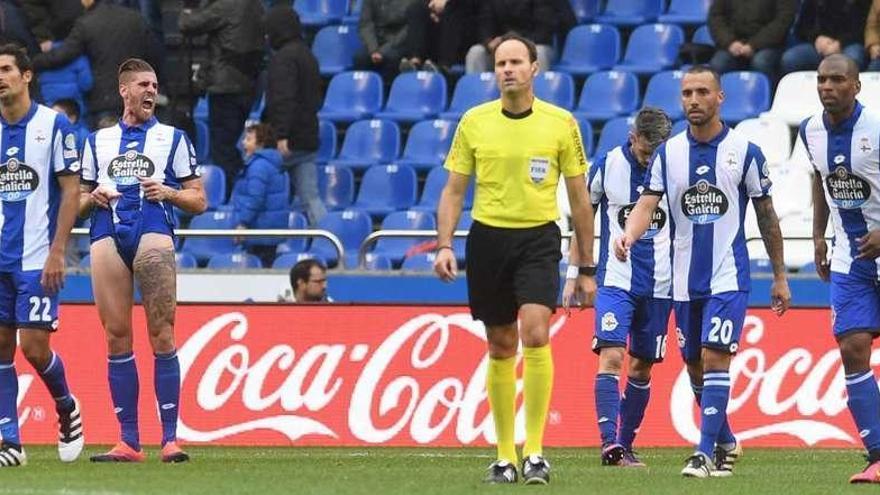 Los futbolistas del Deportivo, abatidos, en presencia del colegiado Mateu Lahoz durante el partido contra el Sevilla del pasado sábado en Riazor.