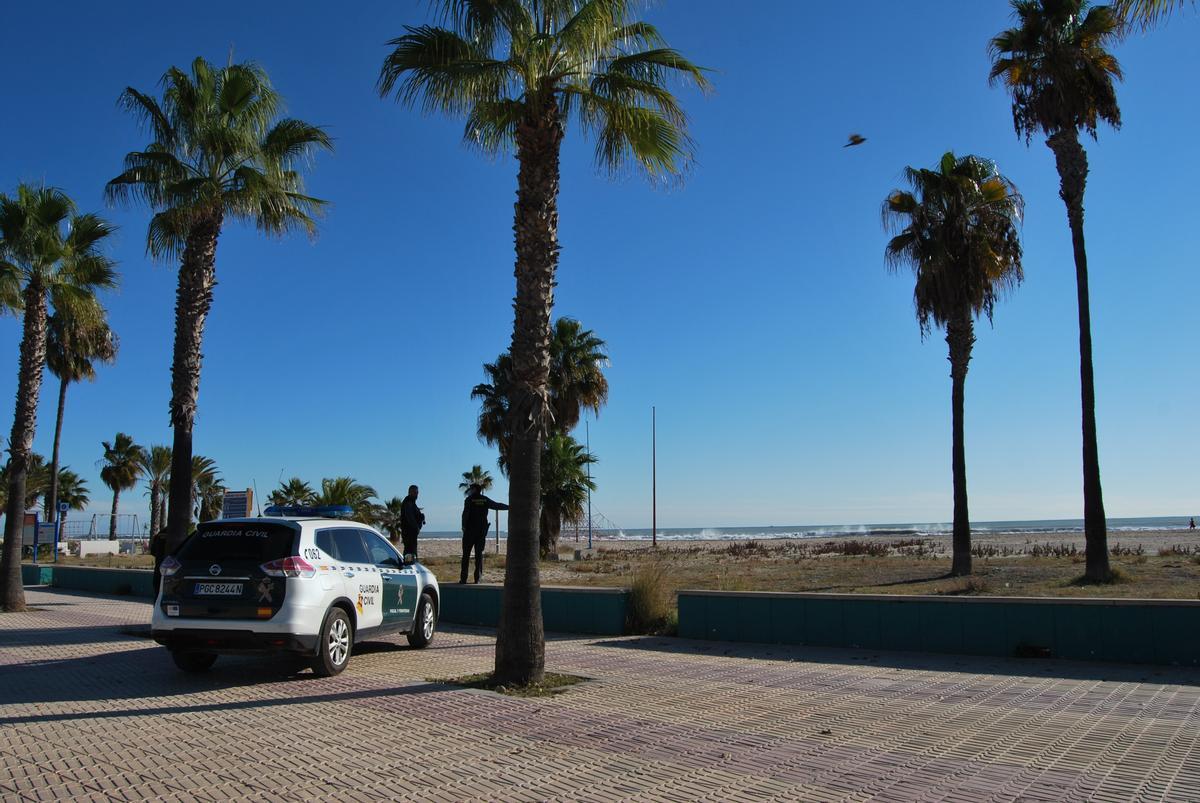 Una patrulla de la Guardia Civil observa las labores en el agua desde el paseo.