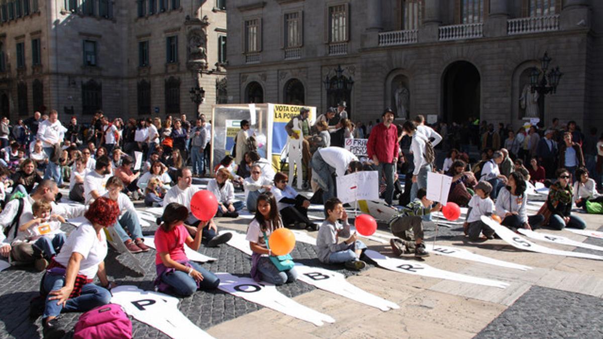 Miembros de la confederación catalana de oenegés, en el acto en contra de la pobreza que se ha celebrado hoy en la plaza Sant Jaume.