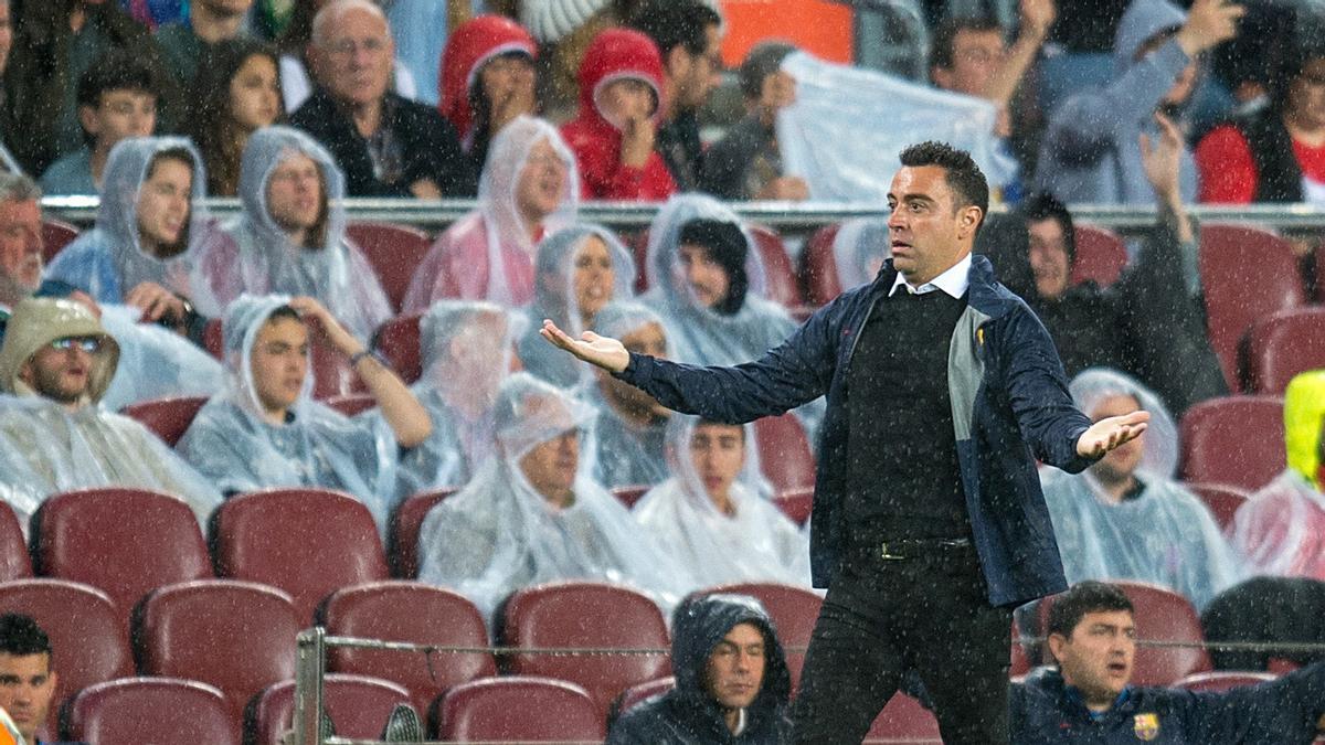 Xavi da instrucciones a sus jugadores bajo la lluvia en el Barça-Betis del Camp Nou.