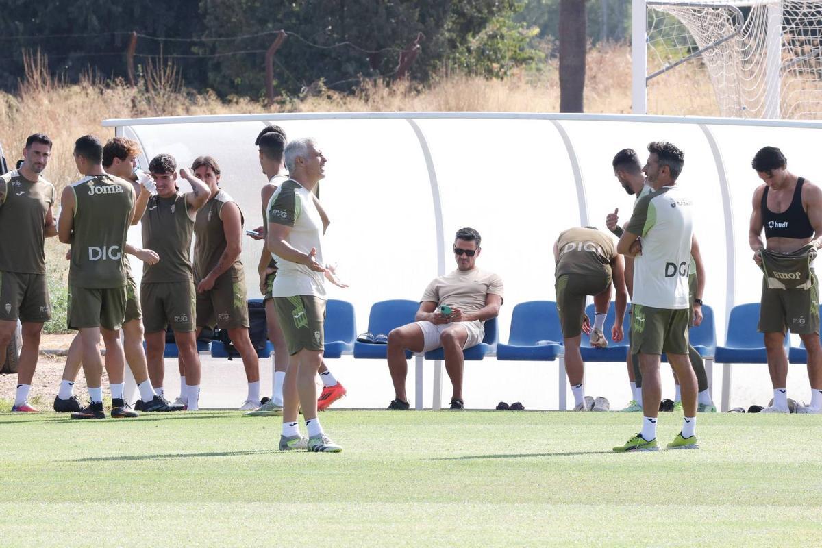El director deportivo, Juan Gutiérrez, en el centro, sigue un entrenamiento en un banquillo.