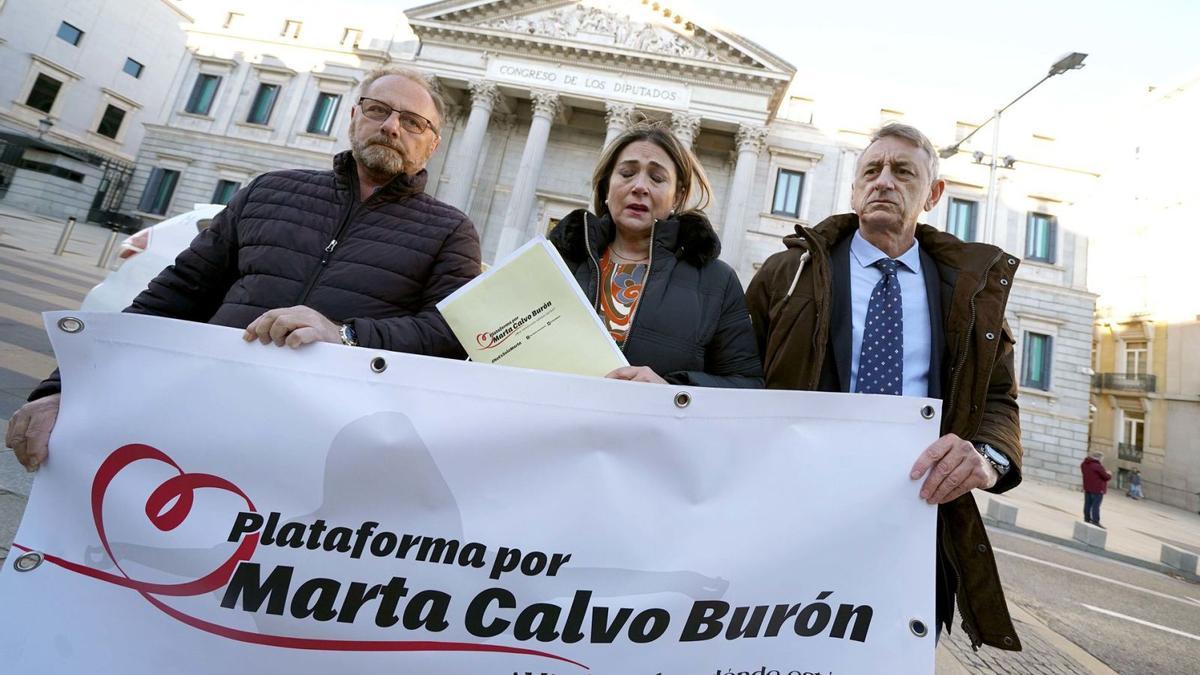 Marisol Burón sujeta la pancarta de la plataforma de la asociación, flanqueada por el padre de Marta del Castillo (izda) y Mariano Navarro. | DAVID CASTRO