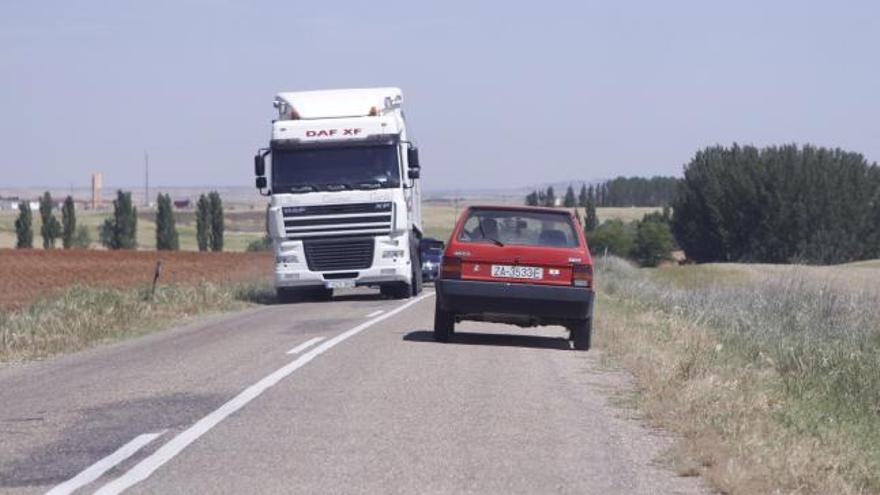 Un camión se cruza con un vehículo por la estrecha carretera de Cañizal a La Bóveda de Toro.