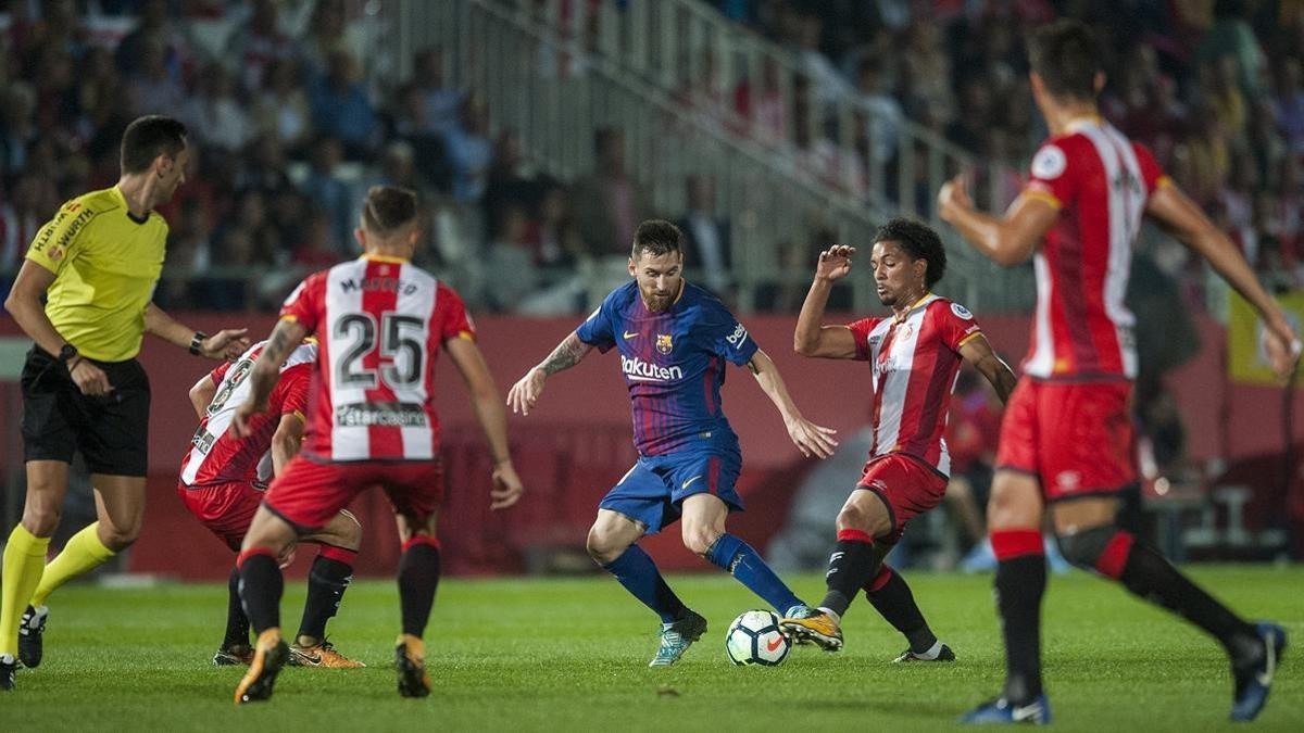 Messi trata de superar a sus rivales del Girona