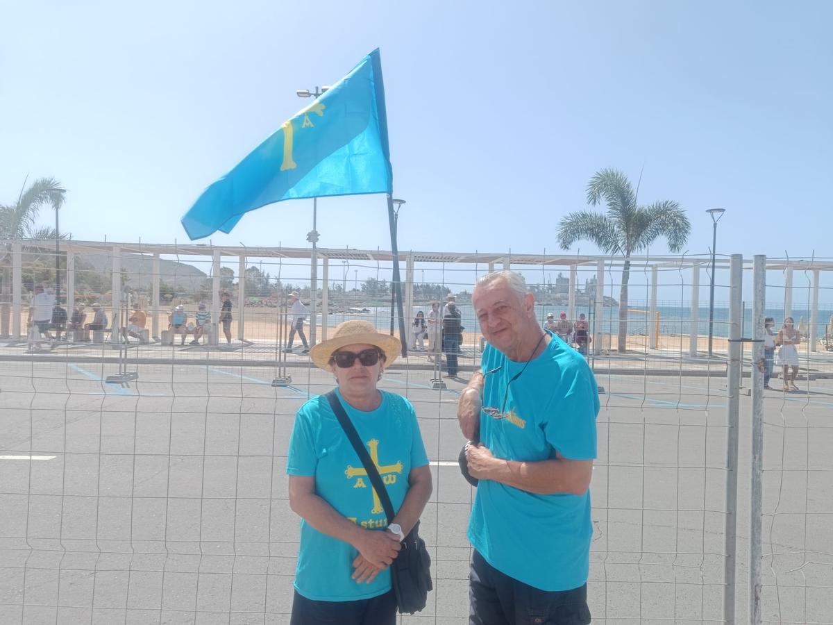 Los asturianos, Rosa Viñuela y Jesús Virgil, con una bandera y camisetas de su comunidad autónoma esperando la llegada de León XIV en la calle José Manuel Santana García.