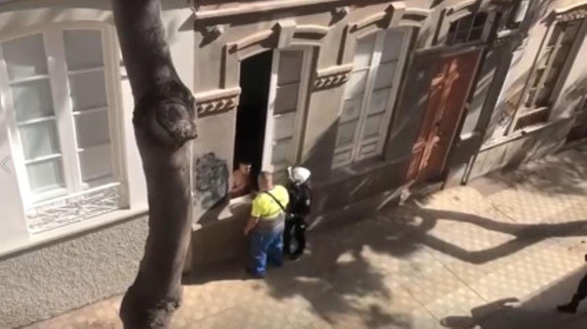 Un policía y un operario hablan con uno de los okupas del Pasaje Segundo Ravina.