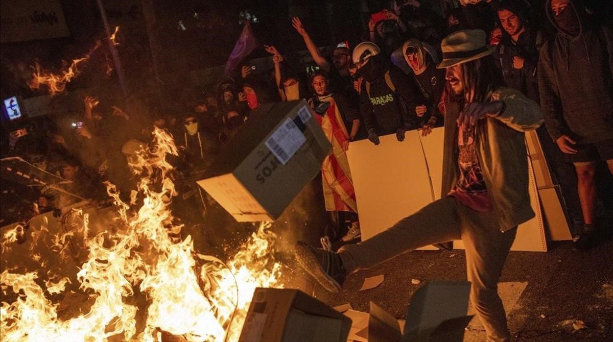 undefined50419809 protesters throw cartons to a burning barricade during clash191015233914