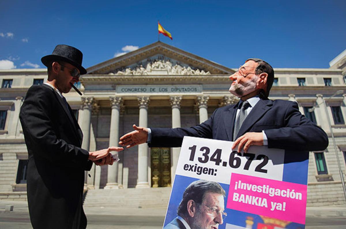 Actors representen els rols de Mariano Rajoy (dreta) i un banquer durant una protesta ’flashmob’ contra el Bankia, davant el Congrés, a Madrid.