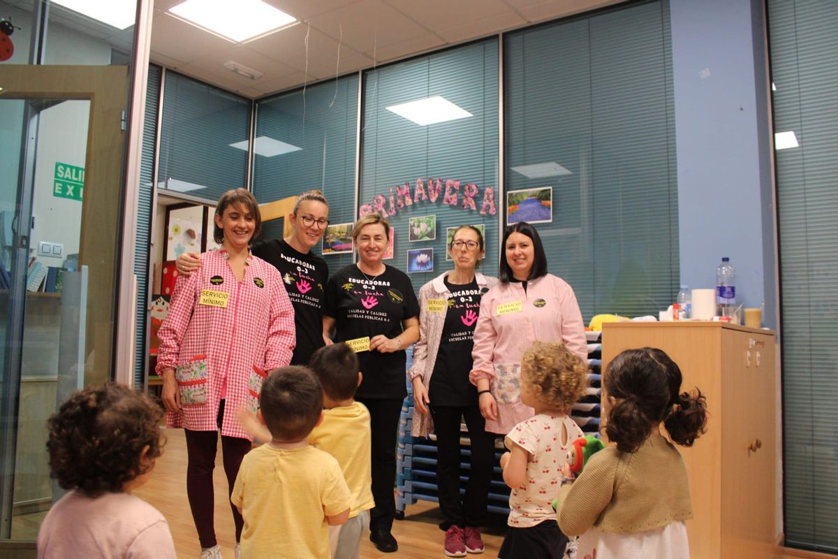 Las trabajadoras de servicios mínimos de la escuelina de Les Xanes, en Mieres, con un grupo de niños.
