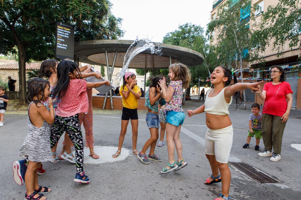 Un grupo de niñas de Sant Celoni, pueblo de 18.000 habitantes sin piscina municipal, se refrescan en una plaza.