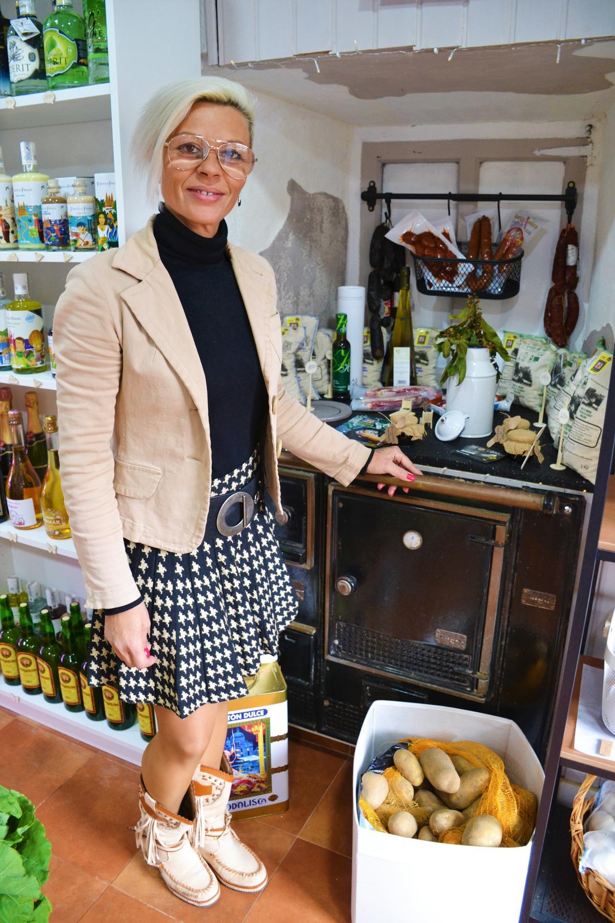 Carmen Suárez en un coqueto rincón de su tienda donde reproduce una antigua cocina de leña.