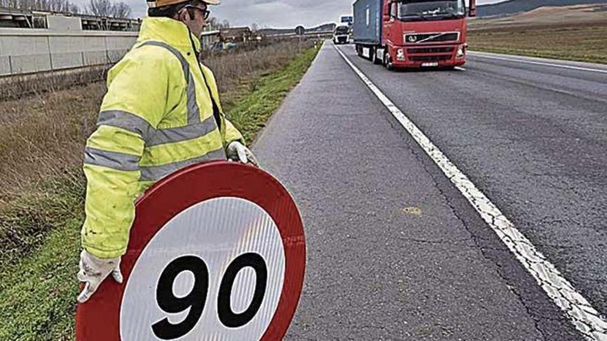 Un operario se dispone a colocar una señal de 90 por hora.