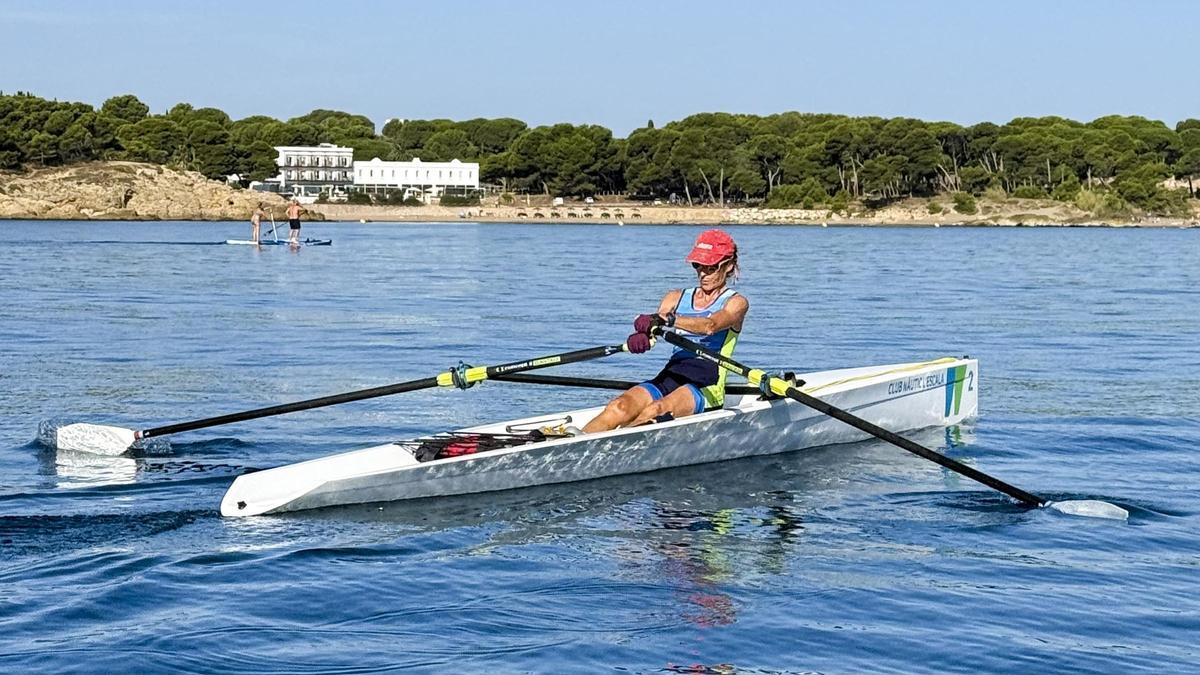 Una caiaquista del Club Nàutic l'Escala, navegant enfront de la costa d'Empúries.