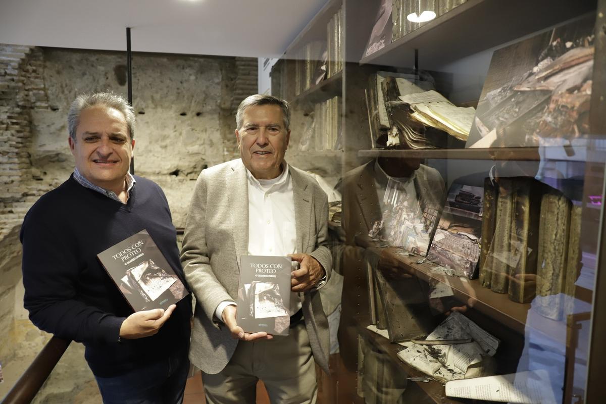 El gerente de la librería, Jesús Otaola y Anastasio Álvarez, promotor 'Todos con Proteo', en el rincón de la librería que recuerda el incendio.