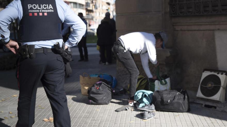 Un agent passa per davant d&#039;un dels desallotjats i les seves pertinences