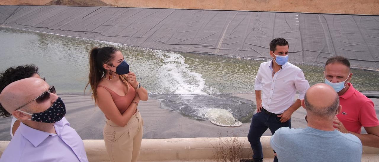 La consellera Mireia Mollà conversa con los regantes mientras el agua entra en el embalse esta mañana