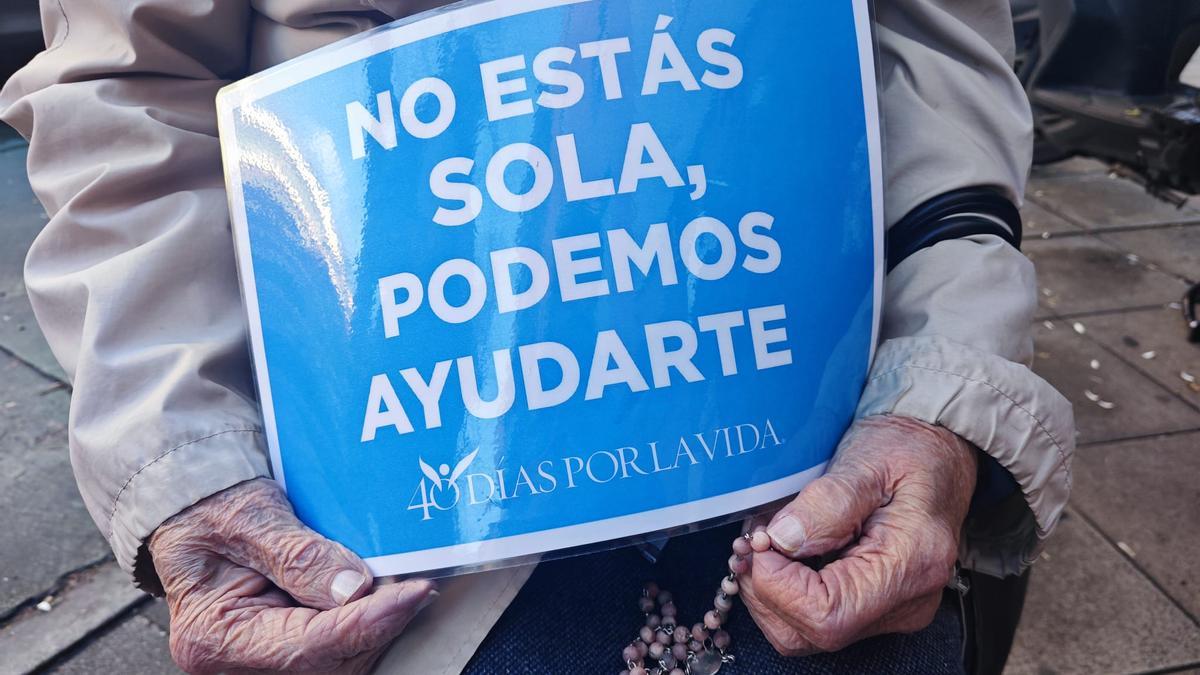 Detalle del cartel que porta una voluntaria de 'Cuarenta días por la vida' en la puerta de una clínica de Sevilla.