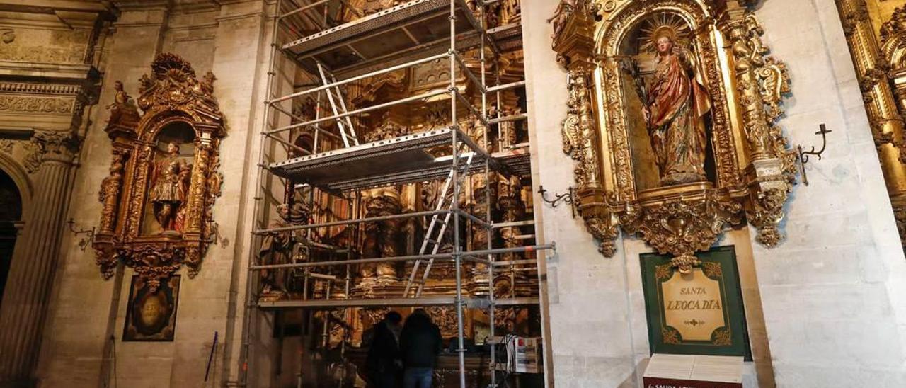 Dos restauradores, trabajando ayer bajo los andamios instalados en el retablo de San Bartolomé.