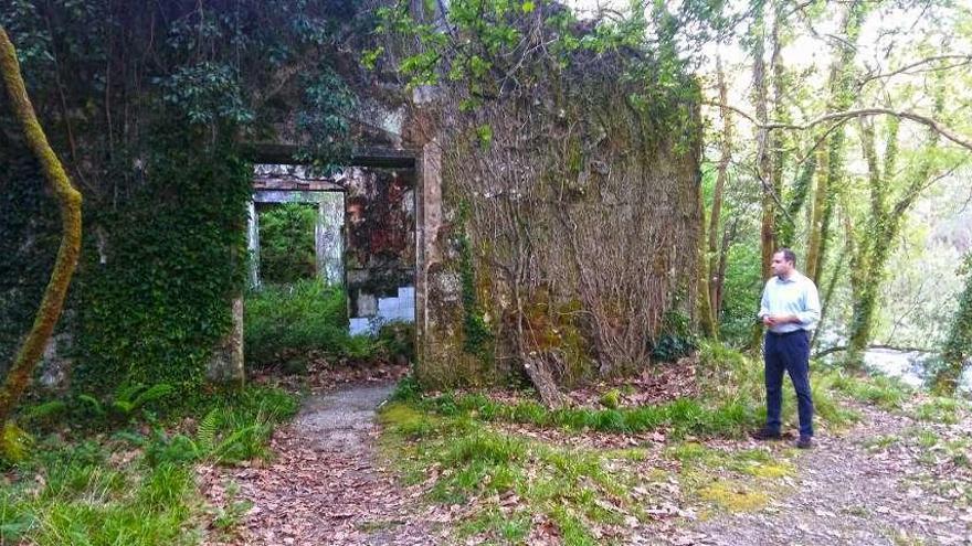 Arriba, Jorge Cubela junto a la antigua minicentral que se reconvertirá en balneario. Abajo, algunas de las bañeras y edificios anexos