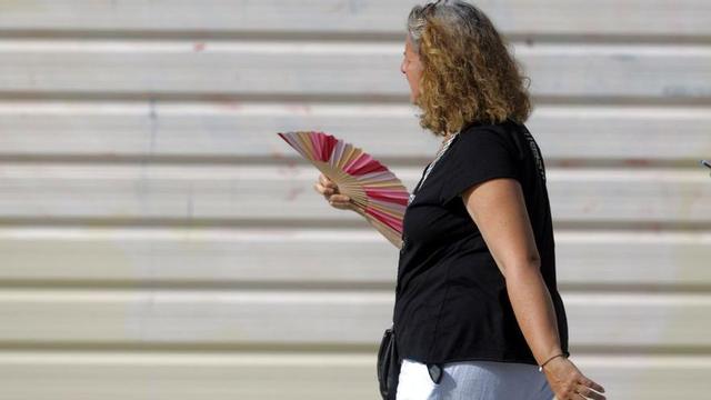 Una mujer se abanica para aliviarse del calor. | MIGUEL ÁNGEL GRACIA