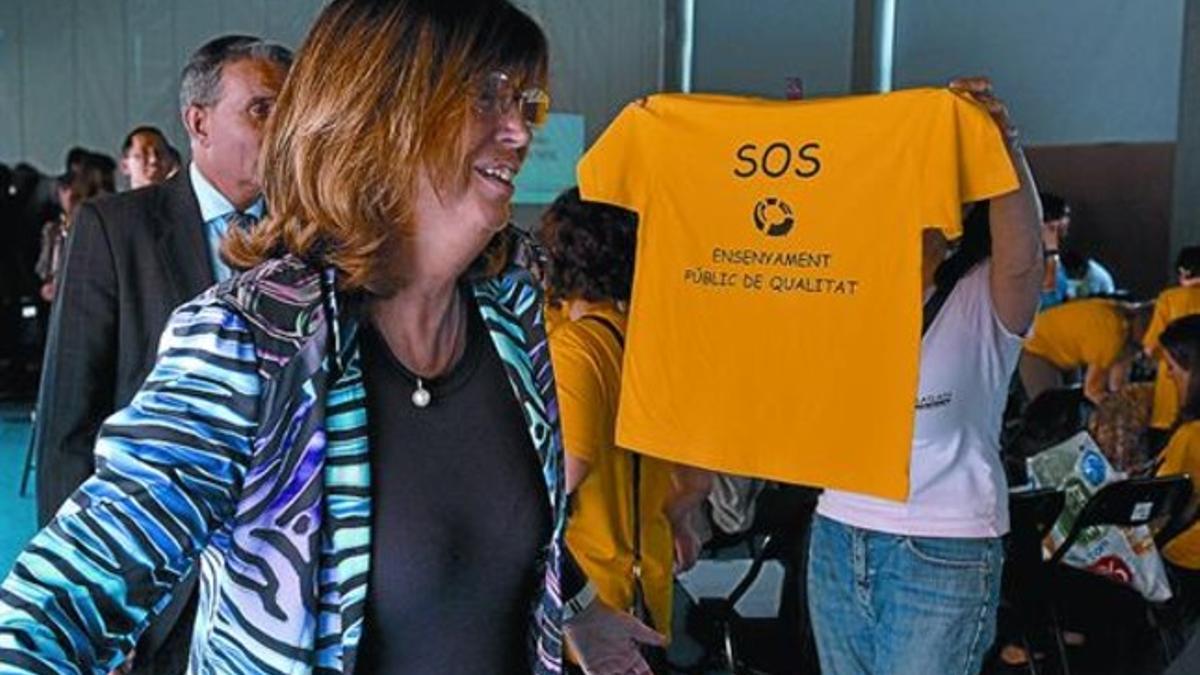 Una madre muestra a la 'consellera' Rigau una camiseta reivindicativa, ayer en Lleida.