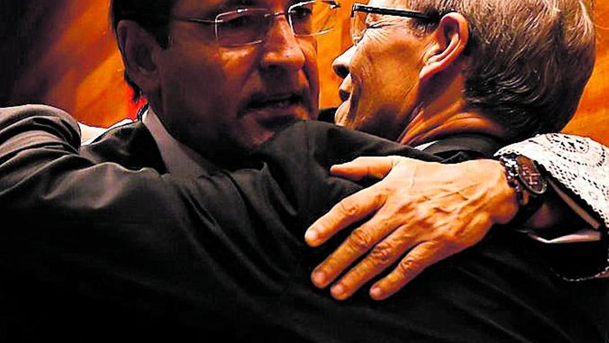 El presidente interino, Carlos Domínguez, se abraza con el expresidente de la Audiencia José Manuel Marco.
