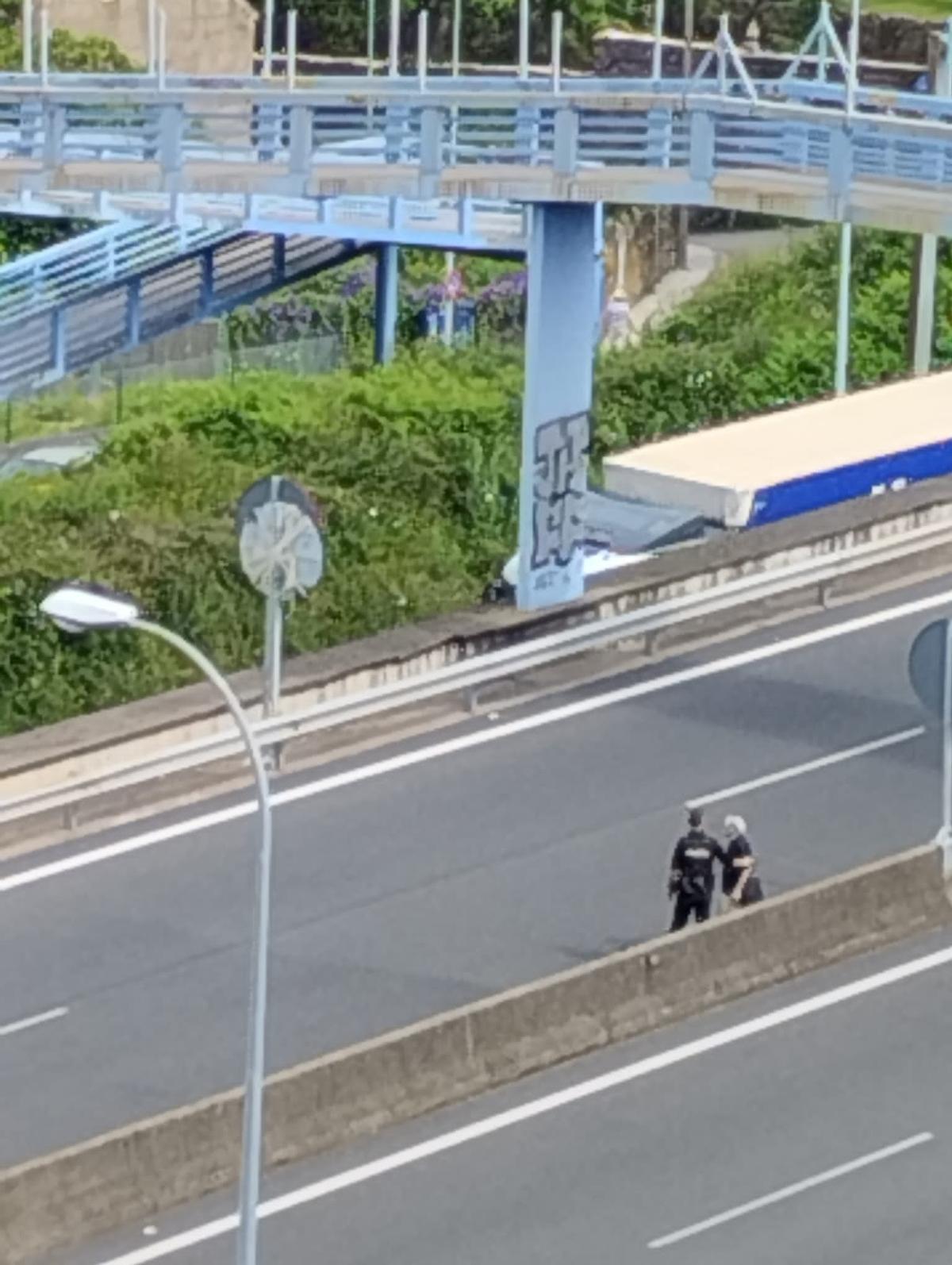 Un agente de la Policía Nacional ayudando al hombre en mitad de la AP-9 en Vigo.